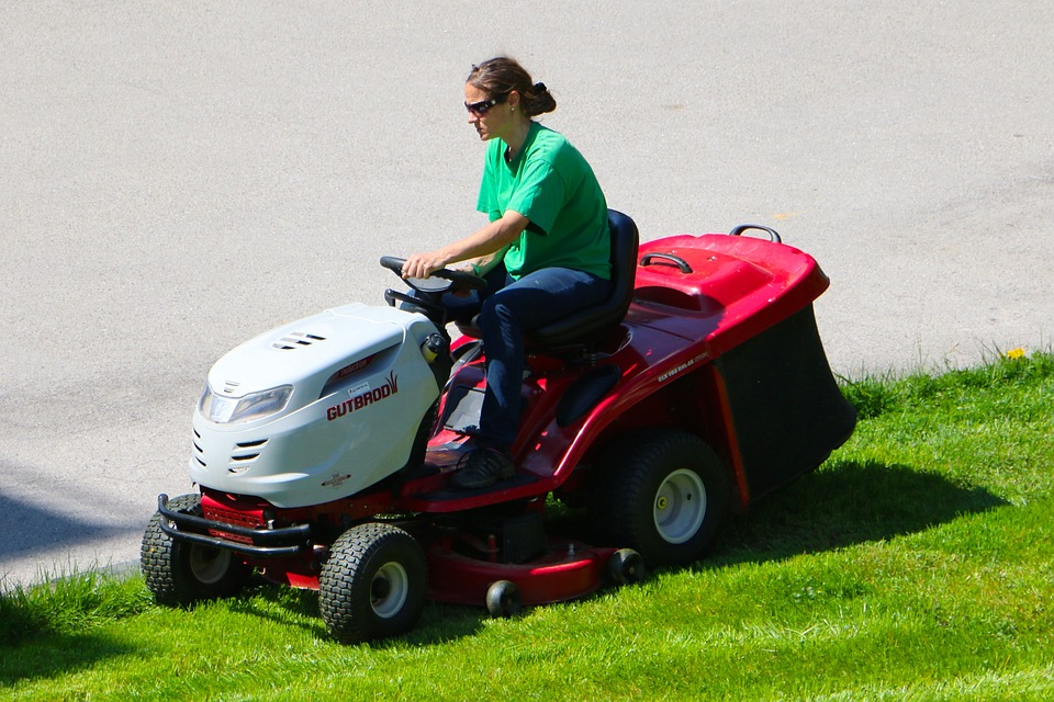 person riding red mower
