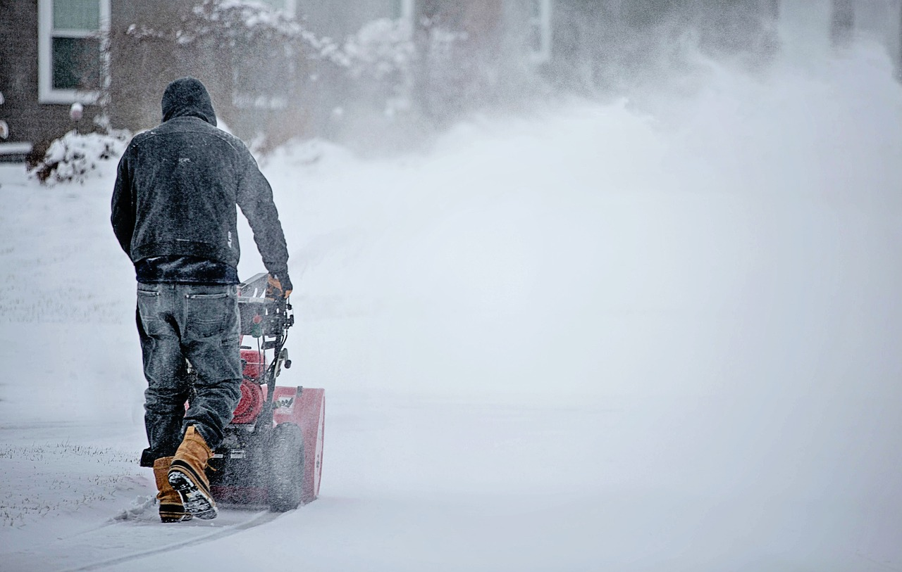 person clearing snow with a machine