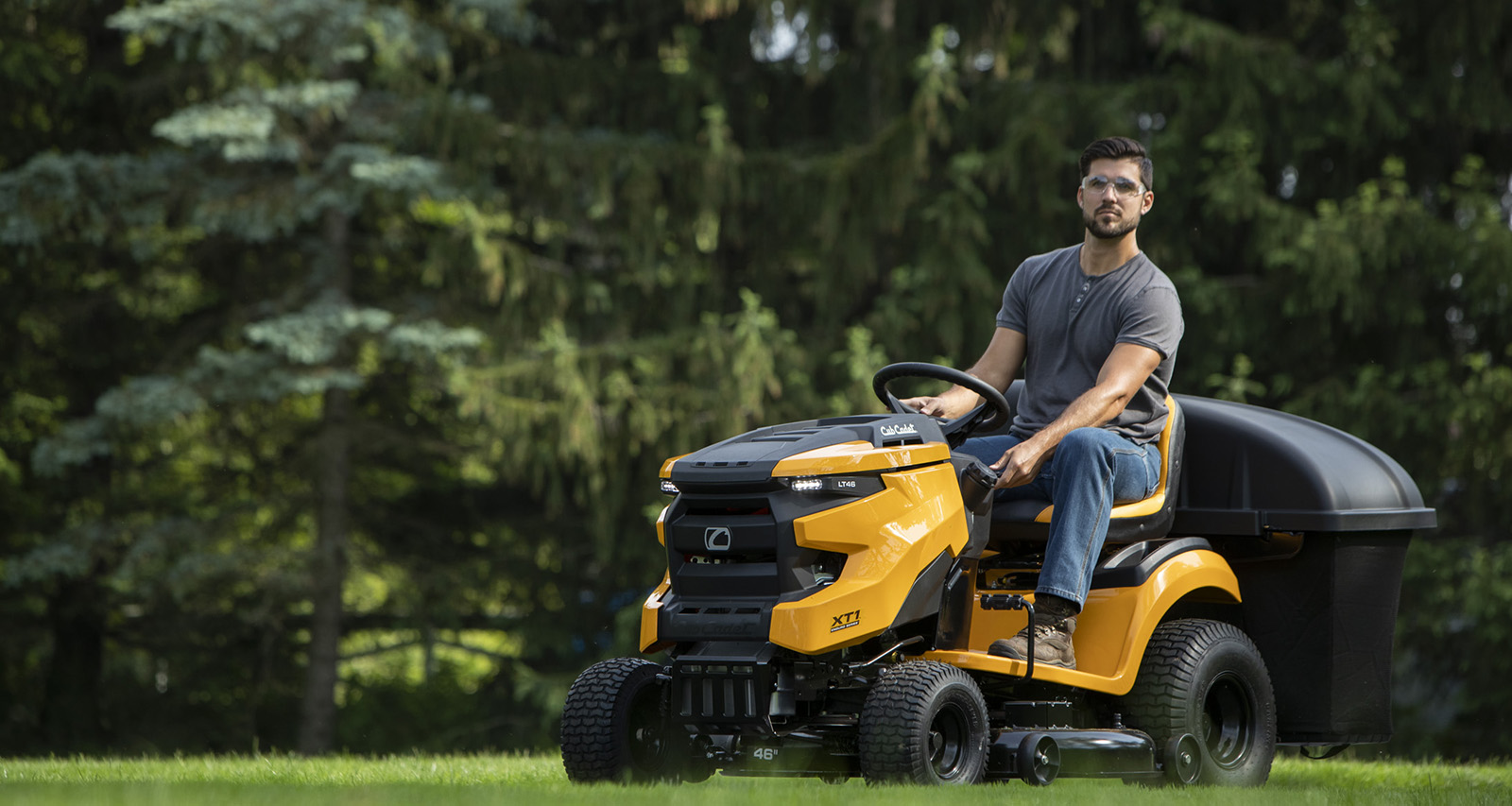 person riding yellow colored lawn mower